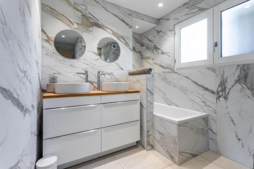 a bathroom with two sinks and a marble wall at Villa Palmier avec piscine in Roquebrune-sur-Argens