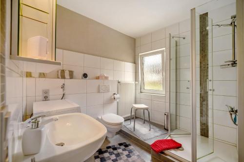 a bathroom with a sink and a toilet and a shower at Haus Gertrud in Monzelfeld