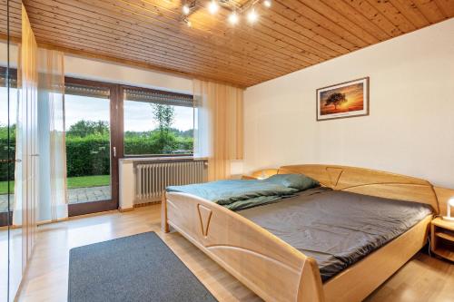 a bedroom with a bed and a large window at Ferienwohnung Raab in Zandt