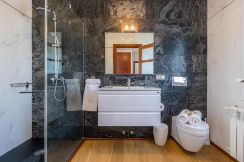 a bathroom with a sink and a mirror and a toilet at Villa Beatriz in Cala d´Or