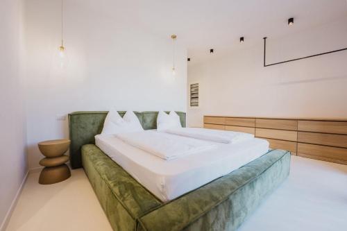 a bedroom with a large bed with a green couch at Artylino in Lazise