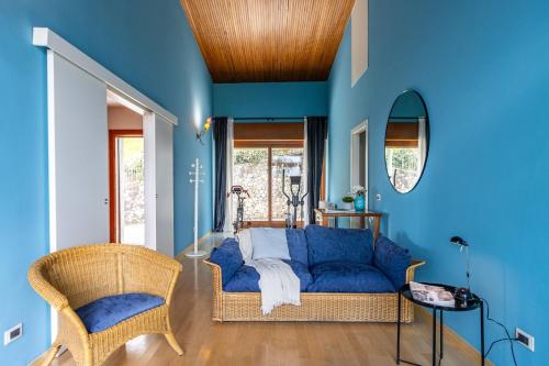 a blue living room with a blue couch and a chair at Al Castagneto Foresteria Lombarda in Montevecchia