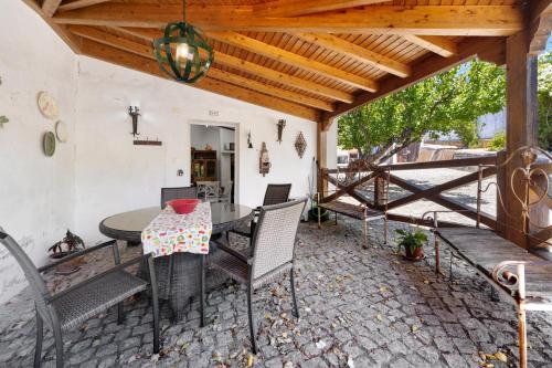 a patio with a table and chairs and a wooden ceiling at Quinta O Refúgio in Azambuja