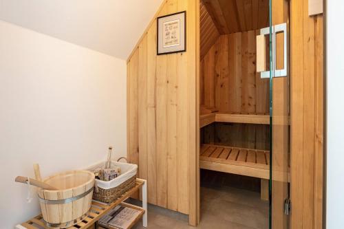 a sauna with a wooden wall and a glass door at Maison Mer Baltique in Dranske