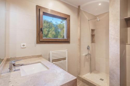 a bathroom with a sink and a shower at Sa Caseta Rustic Villa in Cala d´Or
