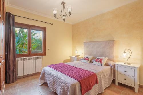 a bedroom with a bed and a window at Sa Caseta Rustic Villa in Cala d´Or