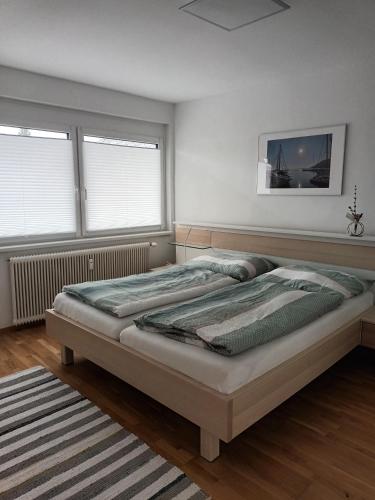 a bedroom with a large bed and two windows at Appartement Kärntner Seenland in Ledenitzen