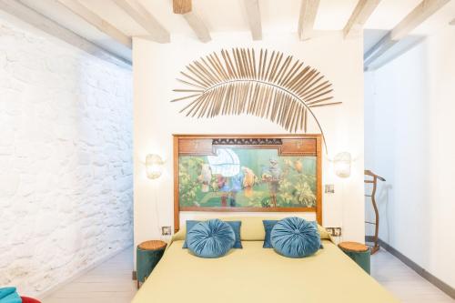 a room with a bed with two blue pillows at La Casona Del Tio Pedro in Cadalso de los Vidrios