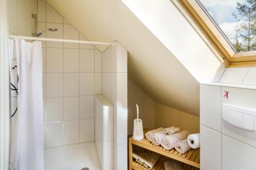 a attic bathroom with a shower and towels at Gulfhof Oldersum Dachgeschoss in Moormerland