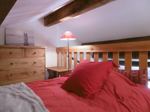 a bedroom with a red bed with a wooden headboard at Logis Des Cerfs in Puyvalador