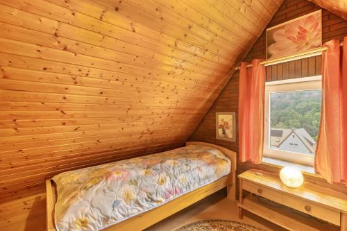 a bed in a log cabin with a window at Ferienwohnung Schloss-See-Bergblick in Waldeck