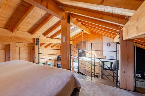 a bedroom with a staircase in a wooden house at Chalet Helnes - chalet contemporain in Saint-Oyen