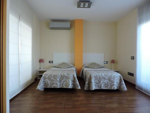 2 Betten nebeneinander in einem Zimmer in der Unterkunft Apartament Ornis Duc Complexe Gorria in Sant Carles de la Ràpita