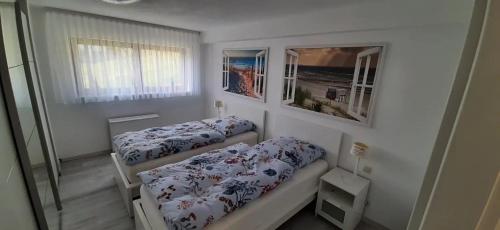 a small room with two beds and a window at Ferienwohnung Küssaberg in Küssaberg