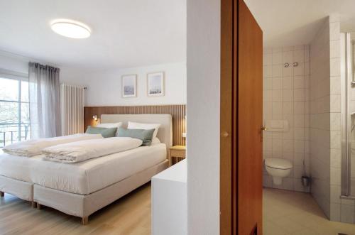 a bedroom with a bed and a bathroom with a toilet at Gästehaus Schwert in Salem