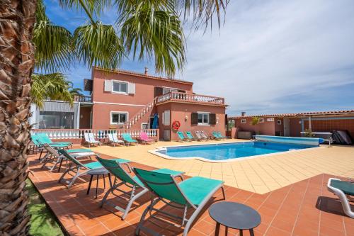 a patio with chairs and a swimming pool at Villa Paradis - Quartos in Pêra