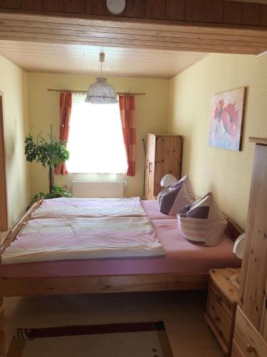 a large bed in a room with a window at Ferienwohnung Strey in Rosenow