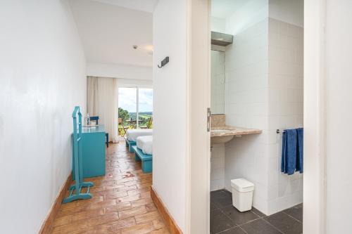 a bathroom with a sink and a bed in a room at Alto da Lua - Aljezur in Bordeira