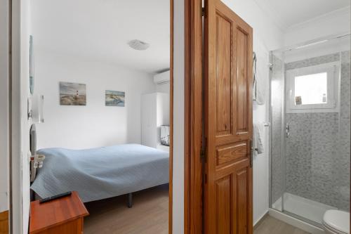 a bedroom with a bed and a bathroom with a shower at Pensión las 3 Golondrinas in Santa Eularia des Riu