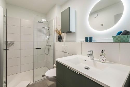 a bathroom with a sink and a toilet and a shower at Husbyries Wohnung 11 in Husby