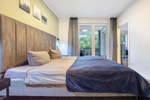a bedroom with a large bed with a wooden headboard at Egge Resort 7g mit Whirpool u Sauna in Altenbeken