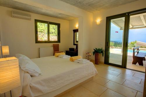 a bedroom with a bed and a sliding glass door at Villa Asterias Ideales Resort in Kefallonia