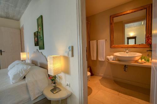 a bathroom with a bed and a sink and a mirror at Villa Asterias Ideales Resort in Kefallonia