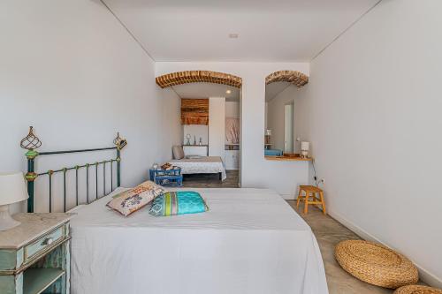 a bedroom with a large white bed with two pillows at Calçada in Alcácer do Sal