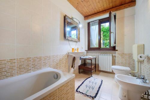 a bathroom with a tub and a toilet and a sink at Il Trucchetto - Castagneto Po in Chivasso