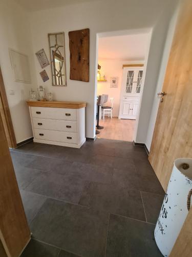 a hallway with a dresser and a room with a door at Waldstein Terrassen in Weißenstadt