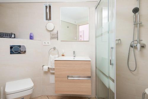 a bathroom with a toilet and a sink and a shower at Can Tamany in Port de Soller
