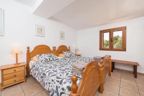 a bedroom with a bed and a table and a window at Can Tamany in Port de Soller