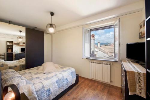 a bedroom with a bed and a window at Romantica e Accogliente Mansardina in Savona
