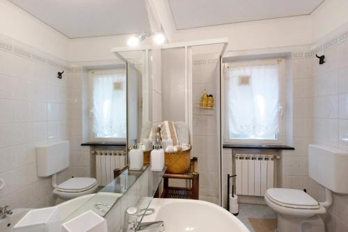 a bathroom with two toilets and a sink and a mirror at Romantica e Accogliente Mansardina in Savona