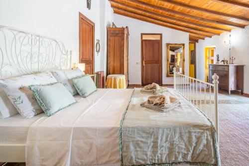 a bedroom with a large white bed with a dog on it at Ca'n Blanch in Biniamar