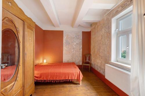 a bedroom with a bed and a window at Altes Pfarrhaus - Wohnung Farbwelt in Hüttenrode