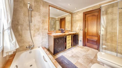 a bathroom with a tub and a sink and a mirror at Costacabana - Villa Beyonce in Lloret de Mar