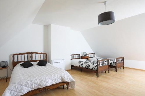 a bedroom with two beds and a table and chairs at Maison familiale Kerriou in Plestin-les-Grèves