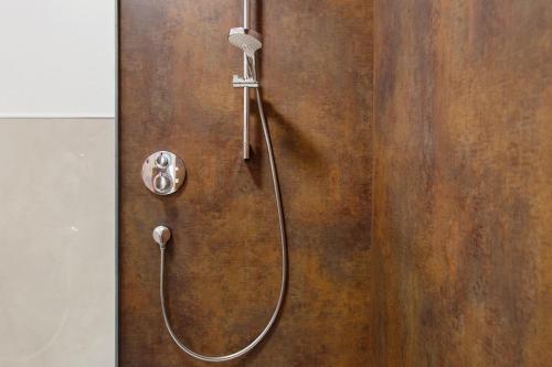 a shower with a hose attached to a wooden wall at Mohnblume in Unterwittighausen