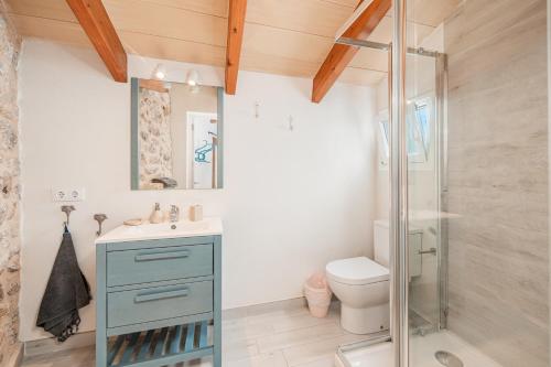 a bathroom with a toilet and a glass shower at La Sastreria in Pollença