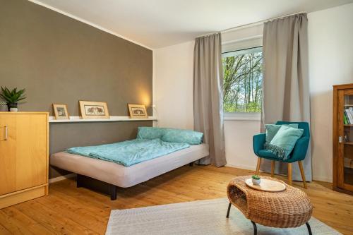 a bedroom with a bed and a chair and a window at Ferien am Lipbachpark in Friedrichshafen