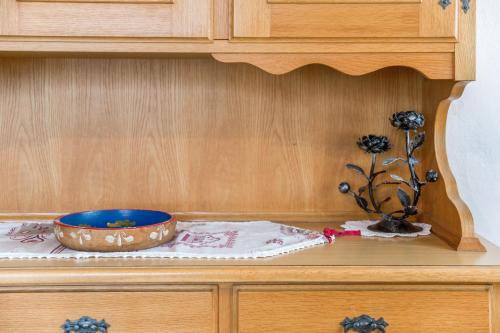 a wooden cabinet with a bowl on a table at Casa Defrancesco - with Garden in Moena
