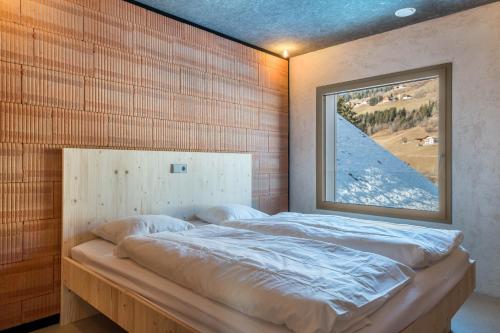 a bed in a room with a picture on the wall at Lena Dolomites Suite in Villnoss