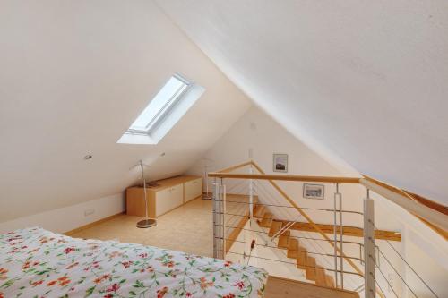 a room with a bed and a staircase with a window at Birkethof Romantik-Appartement in Mickhausen