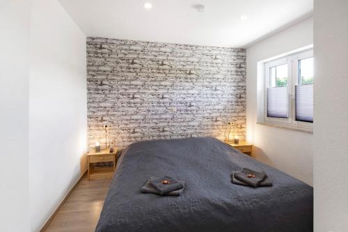 a bedroom with a bed and a brick wall at Ferienwohnung Pfauenhof in Harztor