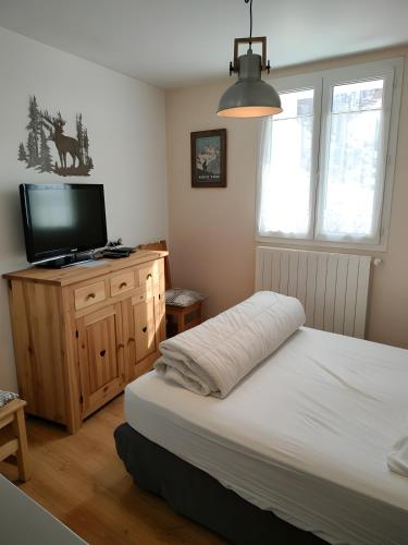 a bedroom with a bed and a flat screen tv at Gite Notre Désir in Abriès