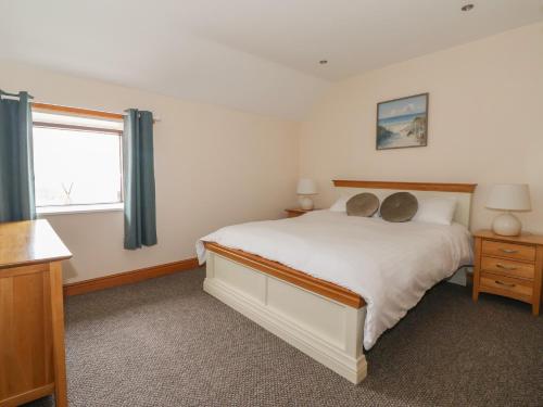 a bedroom with a large white bed and a window at Daisy Nook in Hull