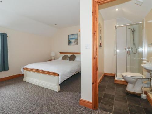 a bedroom with a bed and a shower and a toilet at Daisy Nook in Hull