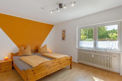 a bedroom with a wooden bed and a large window at Ferienwohnung Eva in Grebenhain