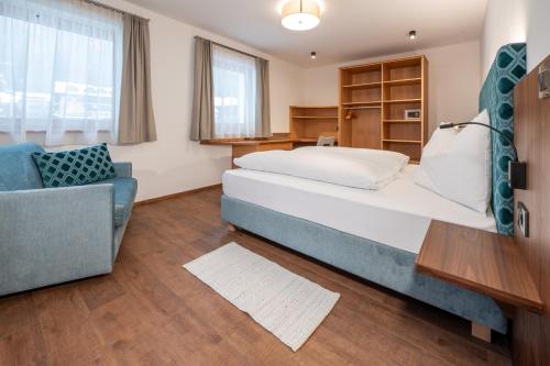 a bedroom with a bed and a chair and a desk at App. Miara - Ciasa Lavarella in San Vigilio Di Marebbe